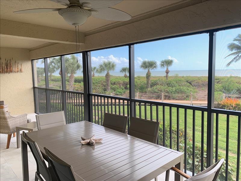 screened in lanai patio with a fan on the ceiling and views of the tropical landscaping and sanibel island beaches